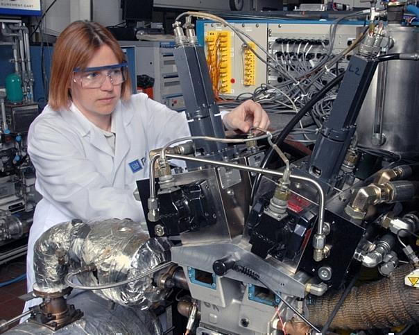 Nicole Wermuth, a GM combustion research engineer, adjusts valve actuators on a single-cylinder research engine used to develop valvetrain requirements for HCCI implementation on a prototype multi-cylinder engine. 